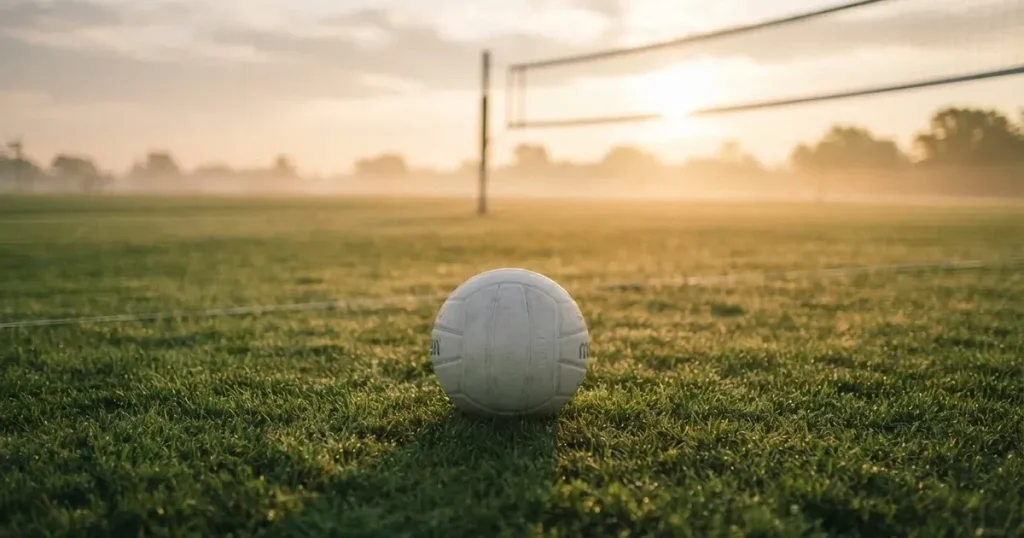 A ball on the centre spot of a grass pitch in morning light